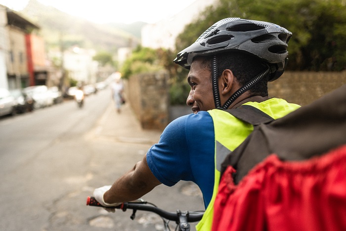 Food delivery biker wearing a helmet on a route