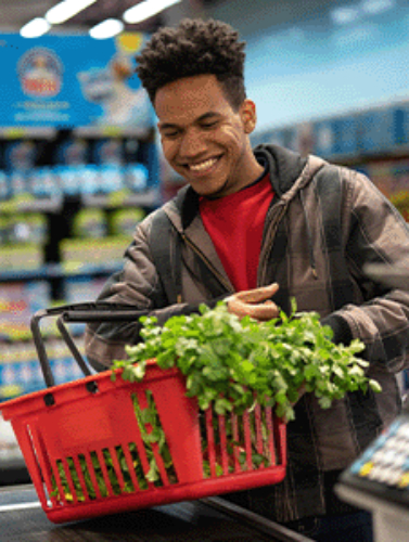 Hombre feliz en el mostrador de la tienda de comestibles