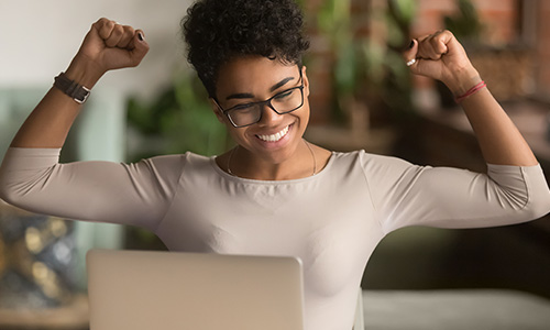 Happy woman smiling at her laptop screen