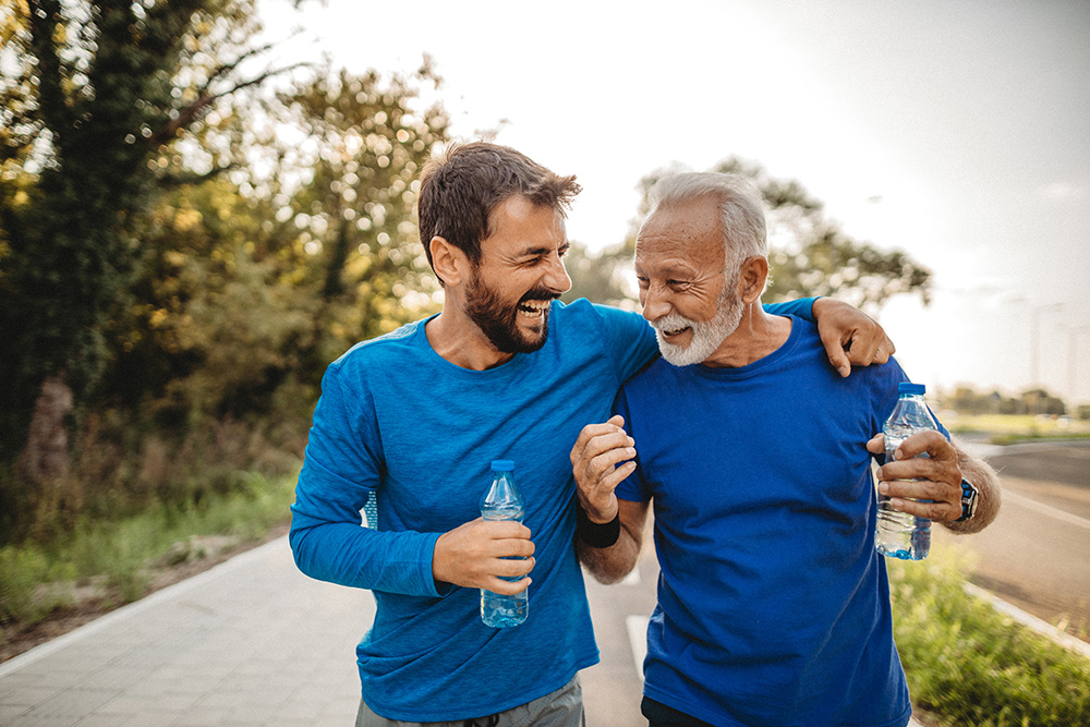 Older father and son walking on a trail. 