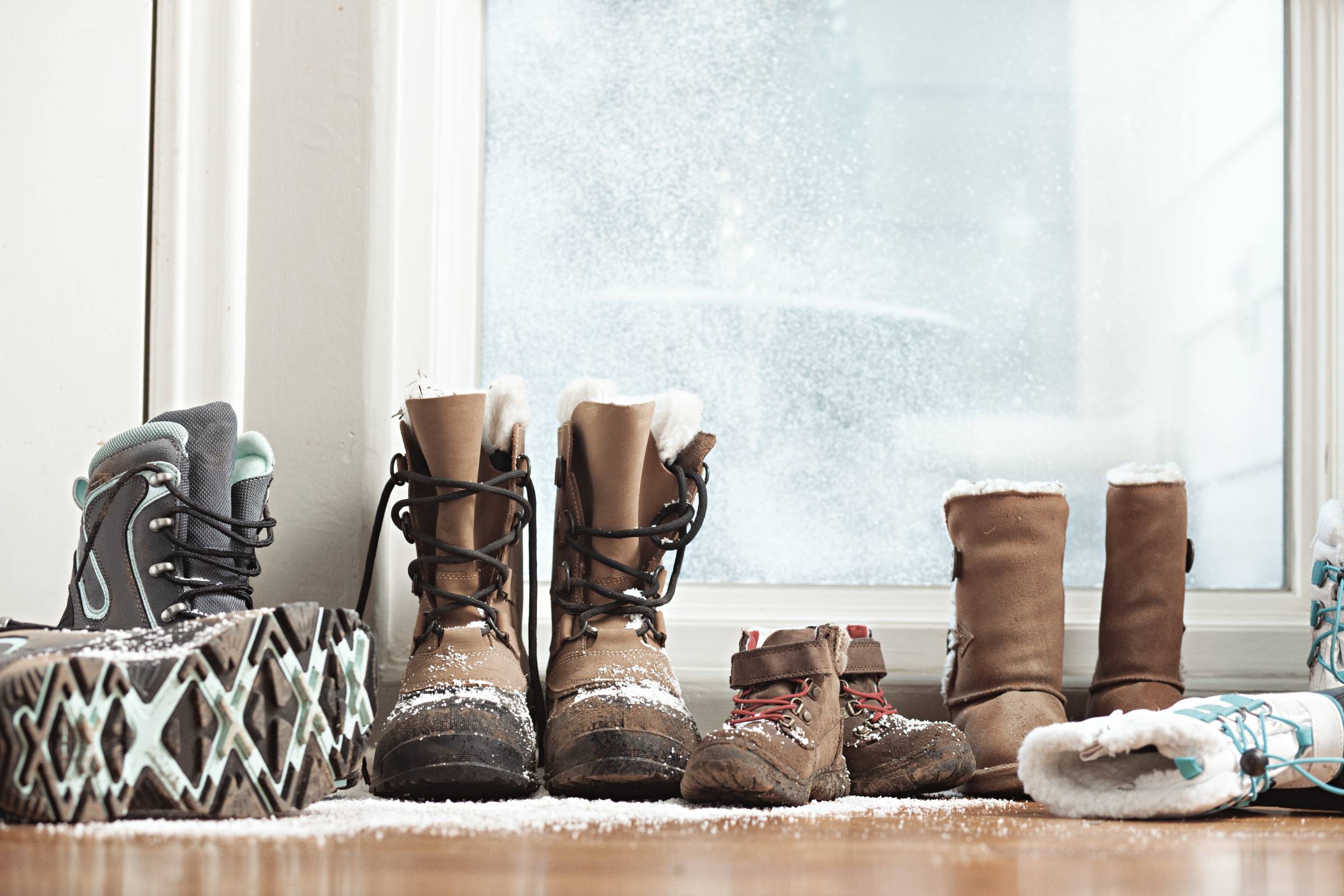 Botas de nieve alineadas junto a la puerta principal.