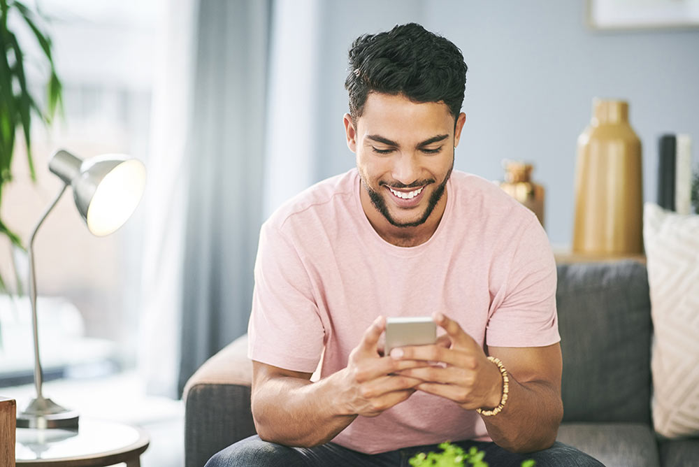 A young man shopping for health insurance on his cell phone.